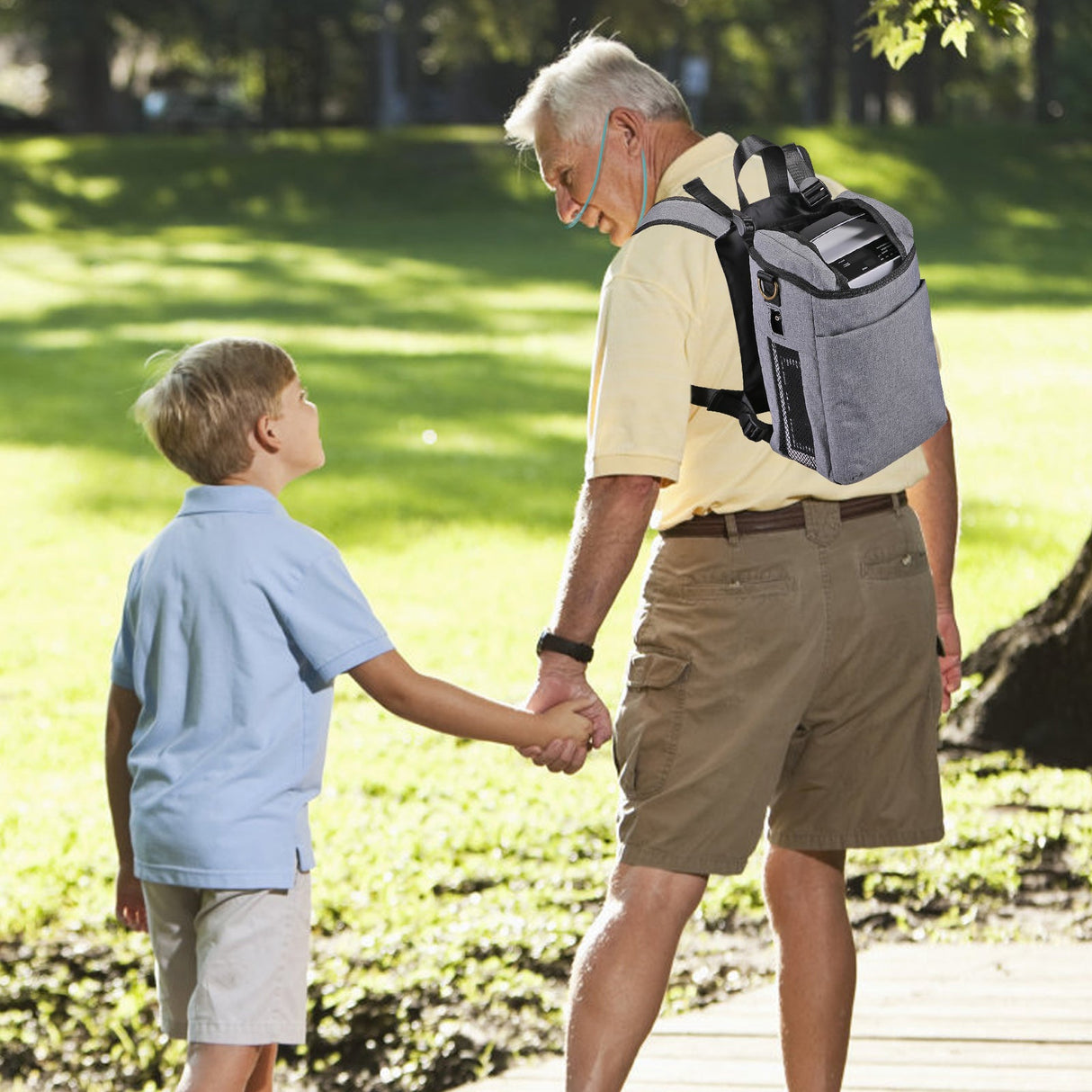 Großvater trägt VARON VP-1 Sauerstoffkonzentrator beim Spaziergang mit seinem Enkel