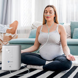Schwangere Frau, die während der täglichen Routine eine Sauerstofftherapie mit dem VARON-Sauerstoffkonzentrator für zu Hause erhält